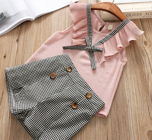 checkered shorts lined with two buttons on each side and flutter sleeveless pink top with extra sting to tie in a bow. 