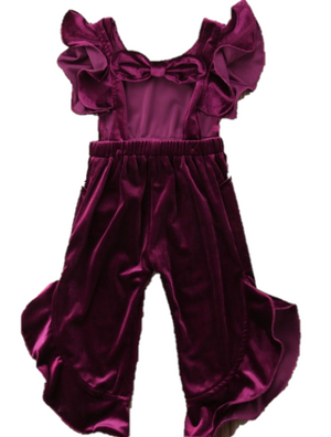 The sleeveless top has ruffles on the shoulders and the back is tied together in a bow. The pants have cascading ruffles lining both sides.