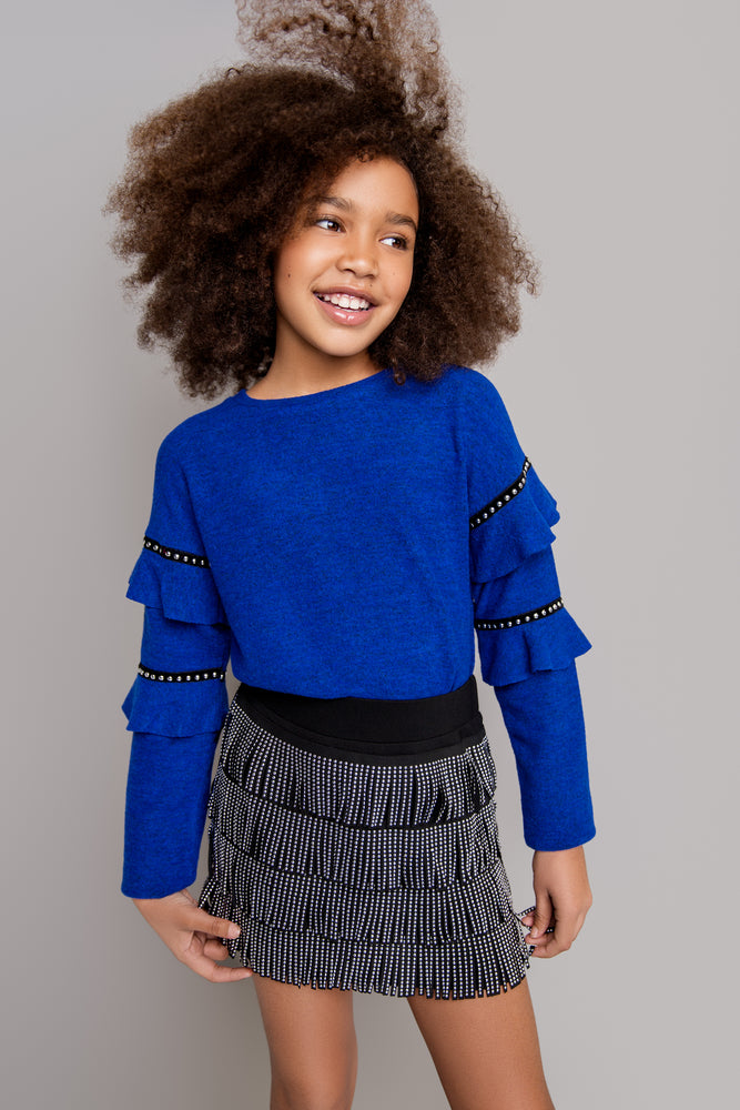 This beautiful Mia NY cobalt blue sweater is sure to make any outfit stand out. With the studded ruffle sleeves and comfy silhouette, it would be paired amazingly with pleather leggings or one of our cute mini skirts. This top can be worn by our toddler diva's all the way up to our tween girls! The Sizes are more fitted so sizing up is recommended if applicable.    Mix and match with our Stud Fringe Skirt and Studded Skater Skirt!